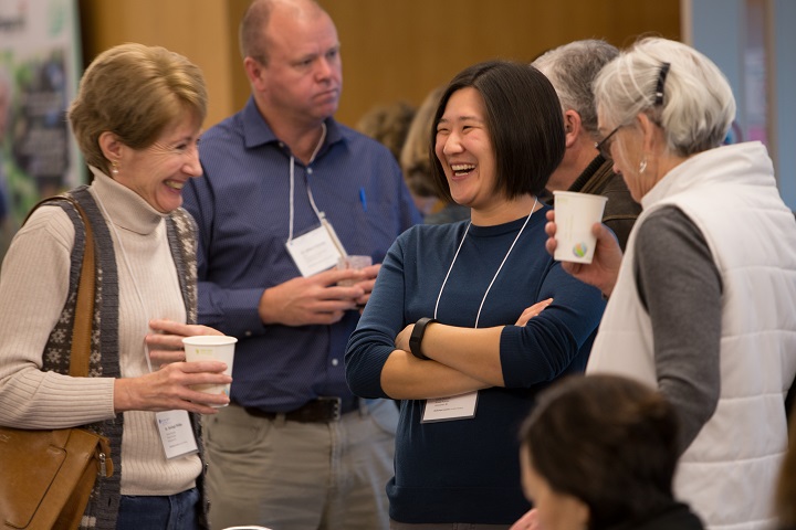 Group of smiling people chatting while wearing name tags