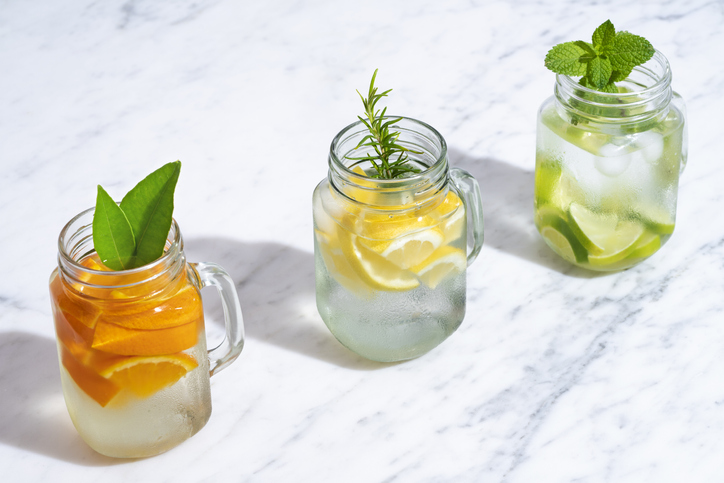 Citrus-infused water in mason jars with orange, lemon and lime fruits