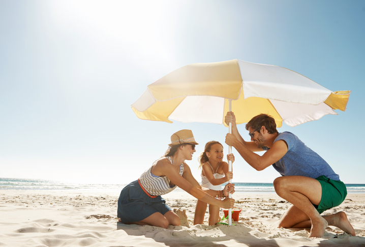 Family putting up umbrella at the beach