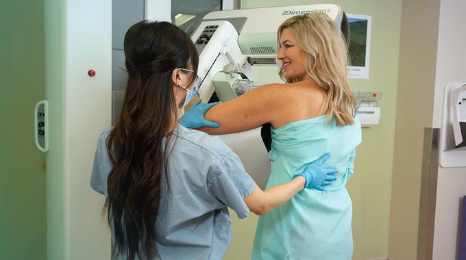 MRT positions a person while getting her mammogram