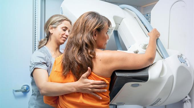 Woman being helped by an MRT while she gets a mammogram