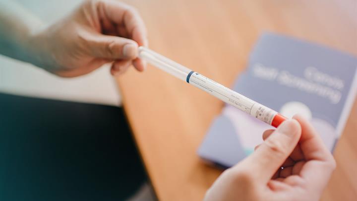 Hands holding cervix self-screening swab