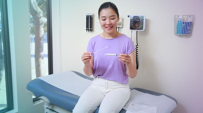 Woman in dr office with cervix self-screening swab