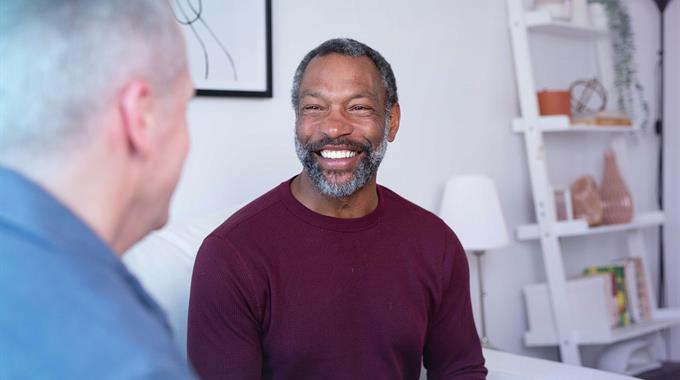 Two people sitting in living room talking