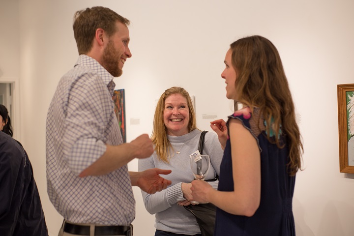 Smiling group chatting at art gallery