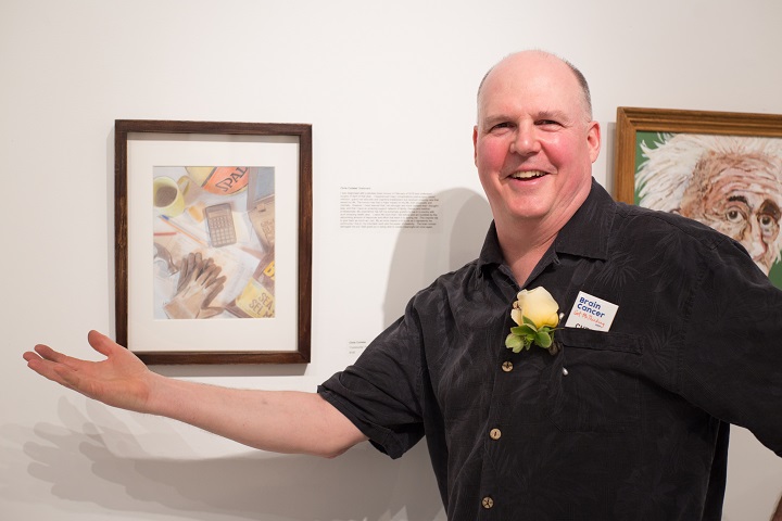 Man shows off painting at art gallery