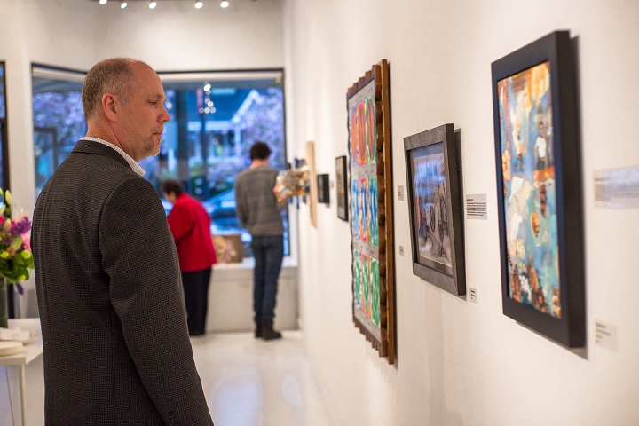 Man contemplates a painting at an art gallery