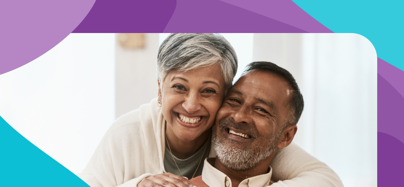 A middle-aged couple smile at the camera