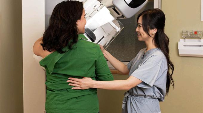 A Technologist positions a patient who is getting a mammogram