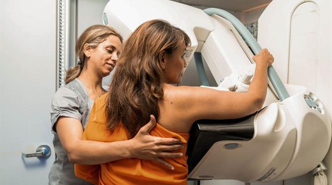 A Technologist positions a patient who is getting a mammogram