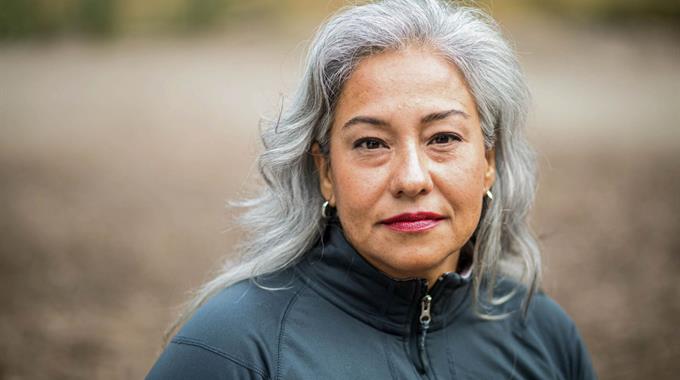 Middle aged woman with silver hair looking into camera