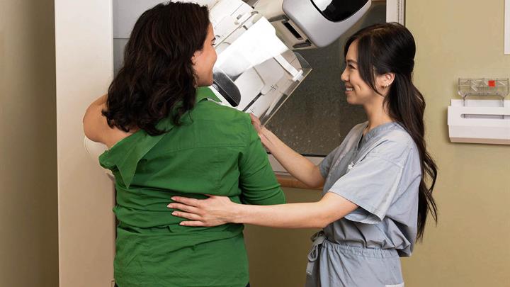 A Technologist positions a patient who is getting a mammogram