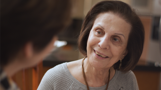 A woman talks to her daughter and smiles