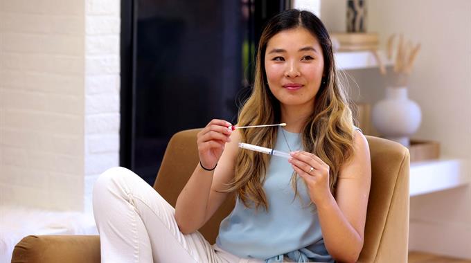 Woman sitting in chair holding swab