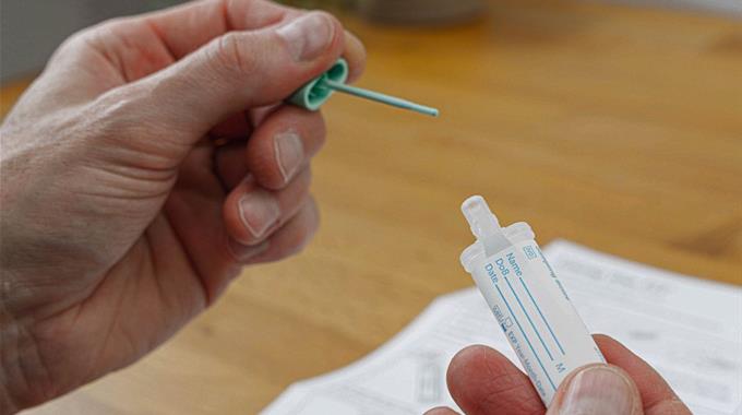 Close-up of person holding FIT with instructions in background