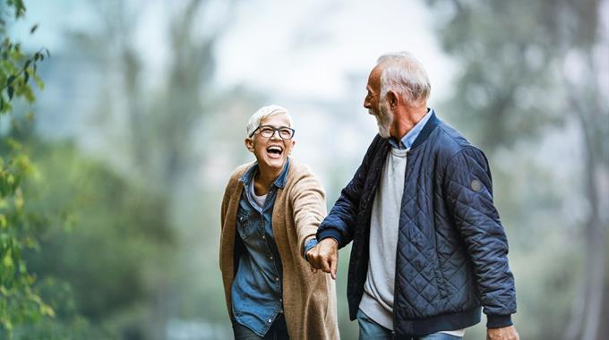 Couple holding hands walking in the woods