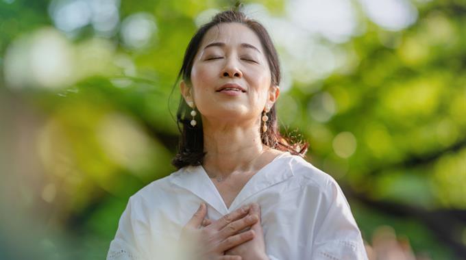 Woman breathing deeply outside in nature